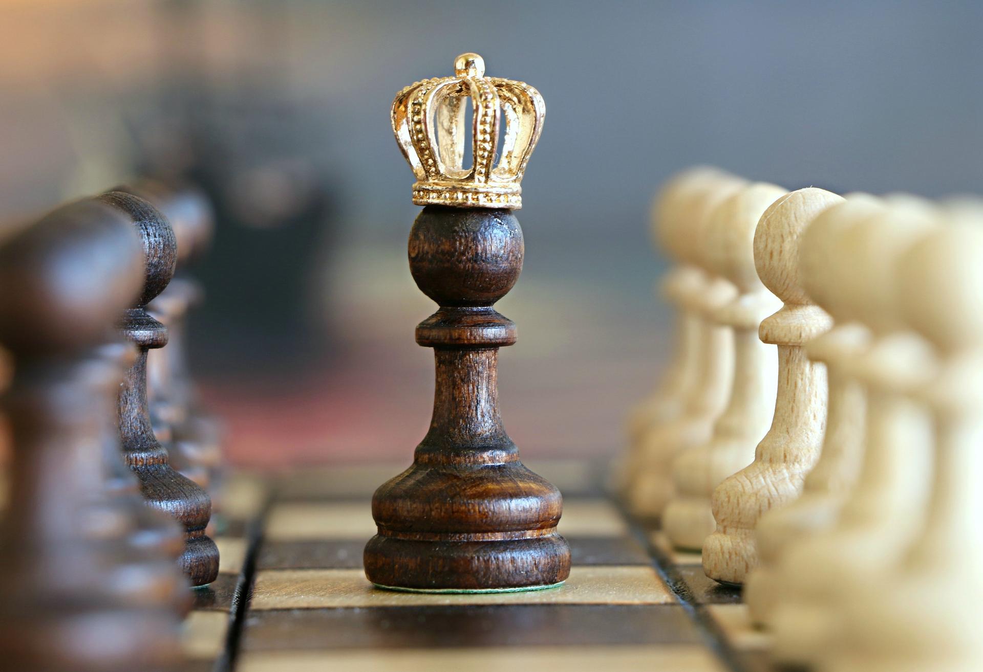 wooden chess pawn with golden crown